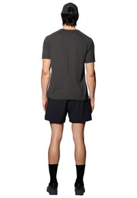 Ciemnoszara dopasowana koszulka z krótkim rękawem i rękawami raglanowymi, w połączeniu z czarnymi szortami. Czarne skarpetki i buty dopełniają sportowy strój.