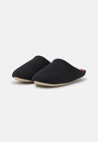 Black slip-on slippers with ribbed texture, soft interior accented in pink, and a tan rubber sole for grip.