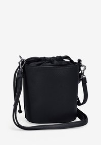 Bolso tipo bucket de cuero negro con superficie texturizada, cierre de cordón y una correa de hombro desmontable. Forma compacta y cilíndrica.