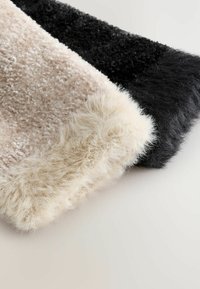 Two faux fur pieces, one in light beige and the other in black, featuring a soft, textured surface and fluffy edges.
