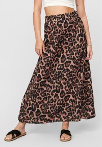 Fustă maxi cu imprimeu de leopard, confecționată dintr-un material ușor, având o talie elastică și o siluetă fluidă. Este disponibilă în nuanțe de maro și negru.
