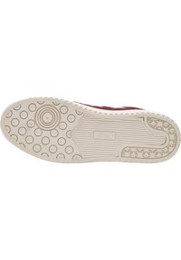 Gummisneaker-Sohle in hellem Beige mit kreisförmigen Mustern und strukturierten Bereichen. Verfügt über ein Logo und erhabene Rillen für bessere Traktion.