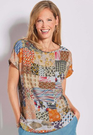 Korte mouwen patchwork top met verschillende bloem- en geometrische patronen in gedempte kleuren, met een ontspannen pasvorm en ronde hals.