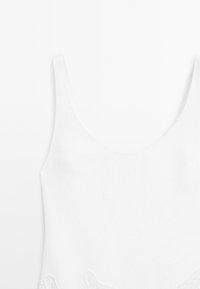 Witte tanktop met een ronde halslijn en dunne bandjes; heeft kantaccenten aan de onderkant; soepel, lichtgewicht materiaal.