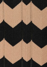 Gebreid stof met een zigzagpatroon in afwisselend zwart en lichtbeige kleuren. De textuur is soepel met gelijkmatige stiksels.