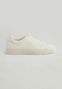 White leather sneaker featuring a textured upper, round toe, lace-up closure, and a flat rubber sole with a minimalistic design.
