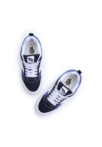 Adidași din suede albastru marin, cu șireturi albe, talpă din cauciuc alb și brand pe limbă. Acestia au un design cu glezna joasă și un guler căptușit.