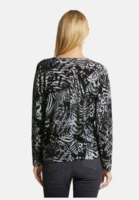 Schwarzer und grauer Pullover mit abstrakten Mustern, langen Ärmeln und rundem Ausschnitt, gefertigt aus einem weichen, strukturierten Strickstoff.