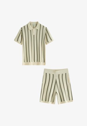Ensemble polo beige à manches courtes et shorts avec motif tricot rayé noir vertical, conçu pour un usage décontracté.