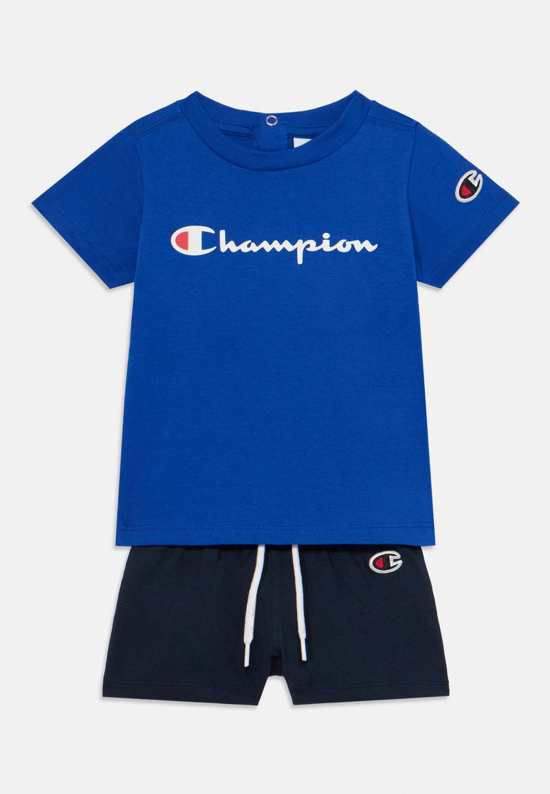 T-shirt in cotone blu con logo "Champion" bianco; abbinato a pantaloni corti blu navy con cordino bianco e logo ricamato sull'orlo.