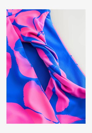 Maillot de bain en tissu bleu et rose avec un motif floral, présentant un design torsadé. Le matériau semble lisse et extensible.