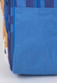 Borsa per il pranzo isolata di colore blu con un tessuto testurizzato, dotata di chiusura con zip e un vivace design grafico nei colori arancione e blu navy.
