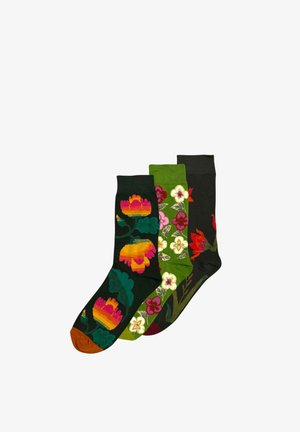 Drie paar kleurrijke sokken met bloemenpatronen in oranje, roze, groen en rood op zwarte en groene achtergronden.