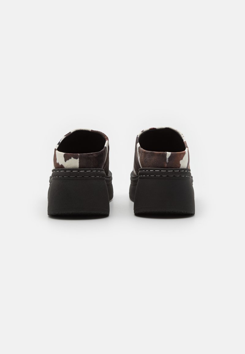 Schwarze Schuhe mit einer strukturierten Gummisohle und einem gemusterten Stoffobermaterial in Braun- und Weißtönen, laces-frei gestaltet für einfaches Anziehen.