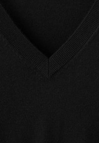 Close-up van zwart gebreide stof met een V-hals geribde kraag, waarbij de textuur en steekdetails zichtbaar zijn.