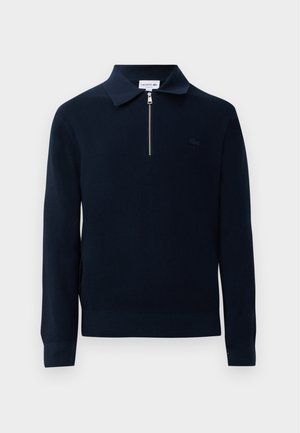 Pullover in maglia navy con colletto con zip, texture a coste, maniche lunghe e un piccolo logo ricamato sul lato sinistro del petto.