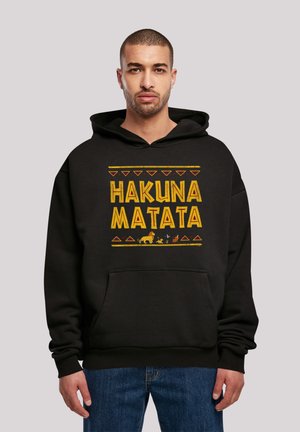 Schwarzer Hoodie mit "HAKUNA MATATA" in Gelb und dekorativen grafischen Elementen, mit einer Kängurutasche und gerippten Bündchen.