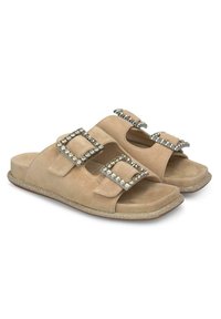 Beige Wildleder-Slide-Sandalen mit zwei quadratischen Schnallen, geschmückt mit Strasssteinen, ausgestattet mit einer strukturierten Sohle und flachem Design.