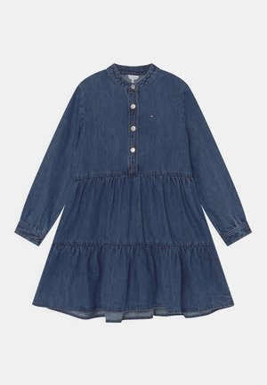 Denim-kjole med lange ærmer og lagdelt skørt, rund halsudskæring med fire knapper foran og lille broderet flaglogo på brystet.