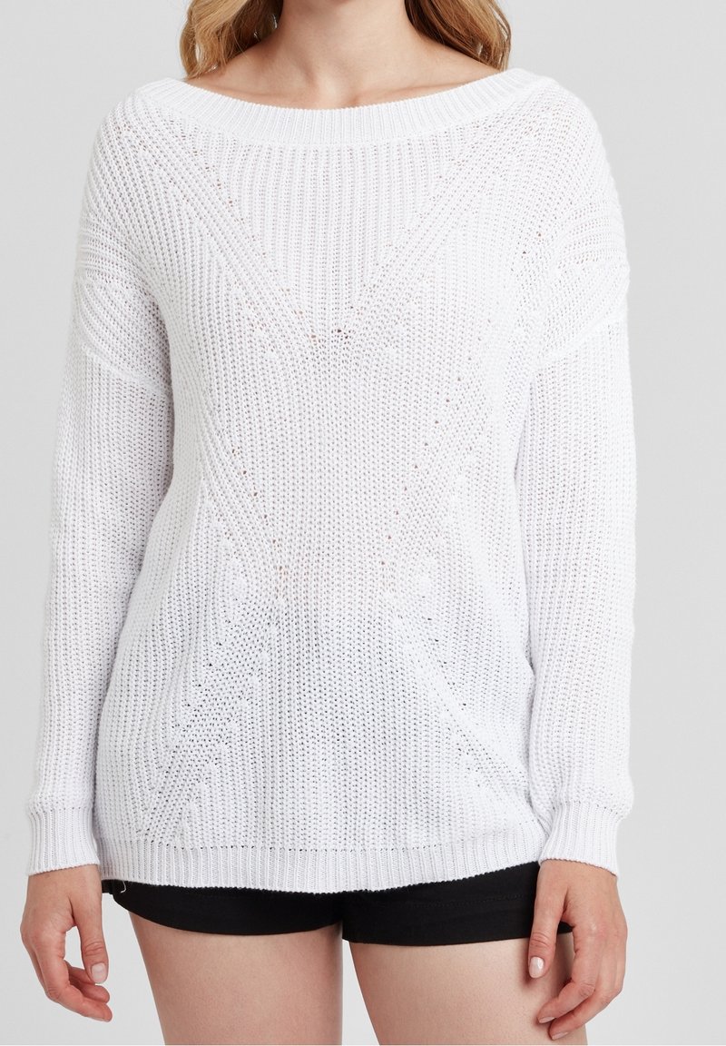 Biała sweter wykonany na drutach o luźnym kroju, z szerokim dekoltem, wzorami teksturowymi oraz ściągaczami przy mankietach i dolnej części. Widoczne krótkie rękawy.