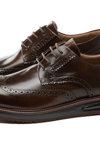 Chaussures brogues en cuir marron avec des perforations décoratives, bout rond et lacets assortis. Présente une semelle en caoutchouc noir contrastant.