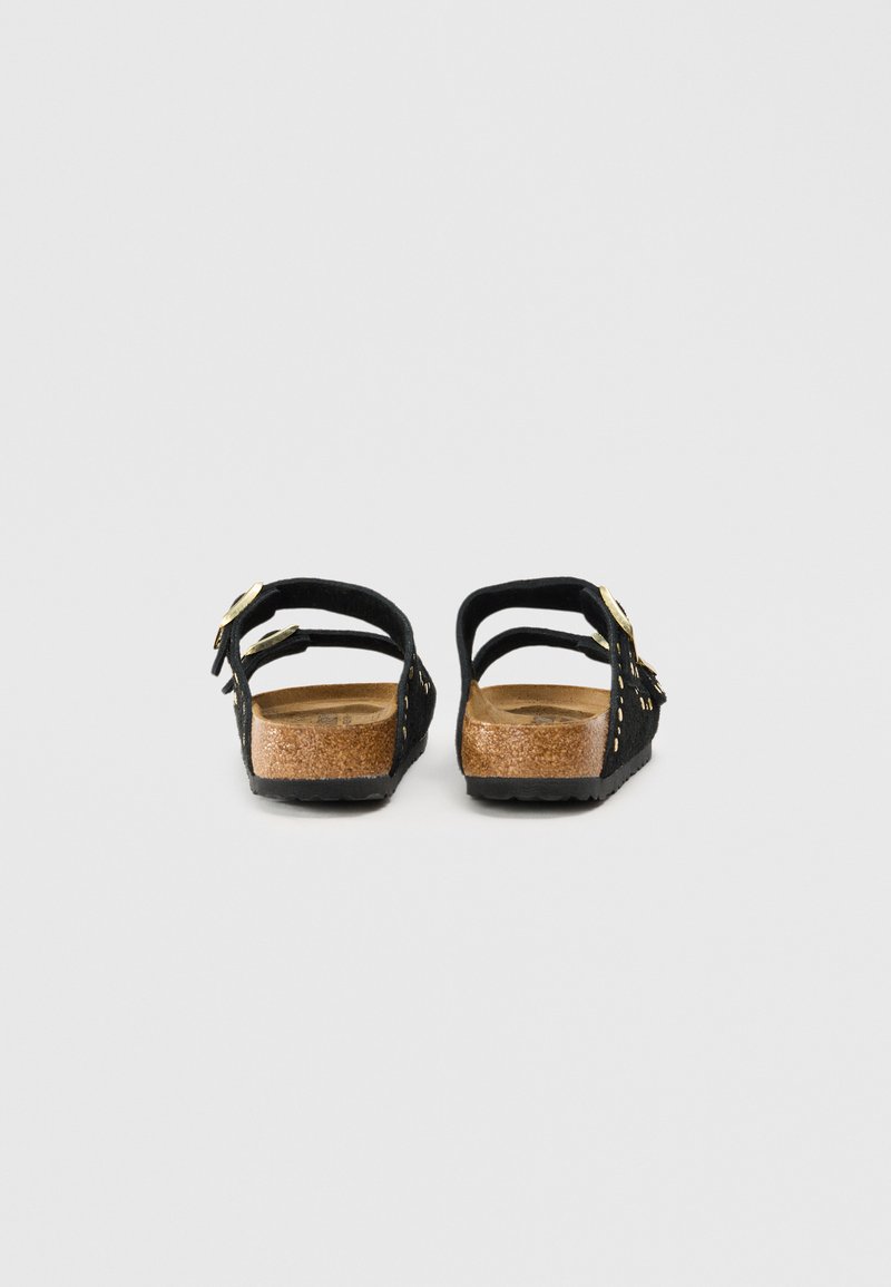 Zwarte suede sandalen met twee verstelbare banden, gouden hardware accenten en een kurken voetbed. Geprofileerde zwarte zool, gesloten achterzijde ontwerp.