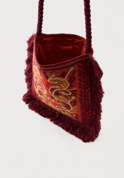 Μικρή ορθογώνια υφασμάτινη τσάντα ώμου με κόκκινη κεντητή λουλουδάτη διακόσμηση, μπορντό φουντωτό περίγραμμα και στριφτό σχοινί λουρί σε λευκό φόντο.