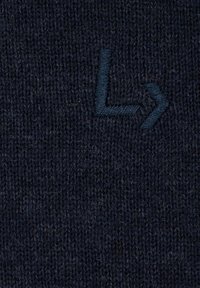 Ciemnoniebieska dziana tkanina z teksturowanym wzorem i haftowanym logo w jaśniejszym odcieniu niebieskiego, prezentująca prosty wzór geometryczny.