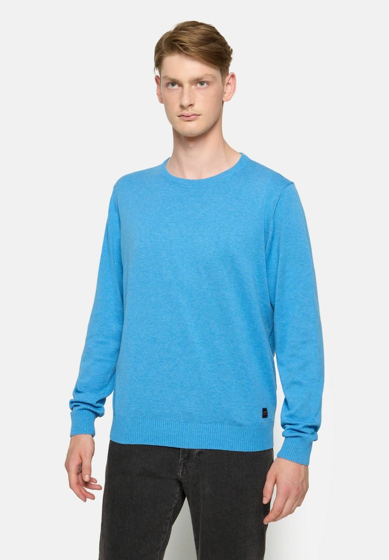 Pulover albastru cu guler rotund, dintr-un tricot texturat, cu mâneci lungi și manșete și tiv cu striații. Etichetă logo neagră în colțul stâng jos.