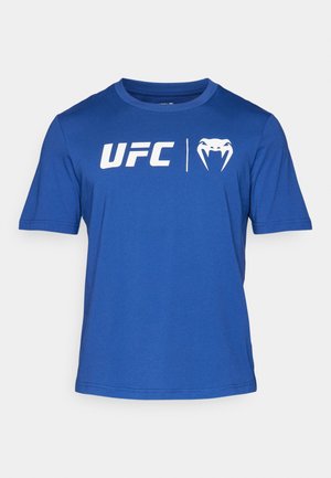 Kratka majica s kratkimi rokavi v modri barvi, izdelana iz bombaža, s prikazom belega besedila "UFC" in logotipa na sprednji strani ter krojnim izrezom in običajnim prileganjem.