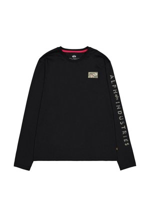 Crna majica dugih rukava s okruglim izrezom, s malim kamuflažnim maramicom na prsima i natpisom "ALPHA INDUSTRIES" ispisanim u sivoj boji na rukavu.