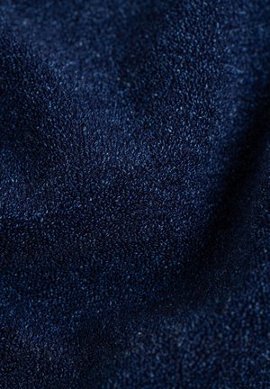 Navy blue textured fabric with a fine, soft weave, displaying subtle variations in shade and depth. Ideal for clothing or upholstery.
