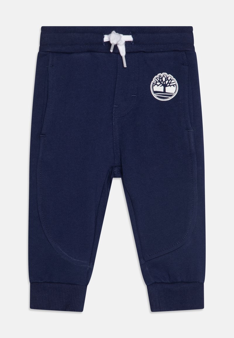 Jogging bleu marine pour tout-petit avec taille et poignets côtelés, cordon blanc, poches latérales et logo arbre blanc sur la cuisse droite.
