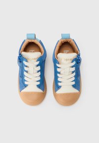 Chaussures basses bleu et blanc en daim et cuir, avec des lacets ronds, une fermeture éclair latérale et une semelle en caoutchouc beige.