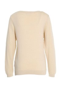 Beżowy sweter o luźnym kroju, z długimi rękawami i szerokim dekoltem. Materiał wygląda na miękki, z delikatną teksturą i prążkowanym wykończeniem.