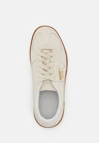 Beige mockaläder sneakers med rund tå, tonala snören och gulllogotyp på sidan. Gummisula med texturerad insida.