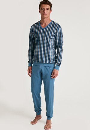 Haut à manches longues bleu et blanc à carreaux avec décolleté en V, associé à un pantalon de survêtement bleu uni ; tissu en coton, coupe décontractée, poignets côtelés aux poignets et aux chevilles.