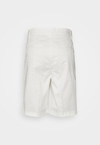 Shorts en coton blancs à coupe droite, avec deux poches arrière et un ourlet propre. Texture lisse sans motifs ni embellissements visibles.