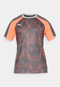 Sivý športový dres s oranžovými sieťovanými rukávmi, ktorý má vlnitý vzor v oranžovej farbe. Vyrobený z ľahkého, vlhkosť odvádzajúceho materiálu.
