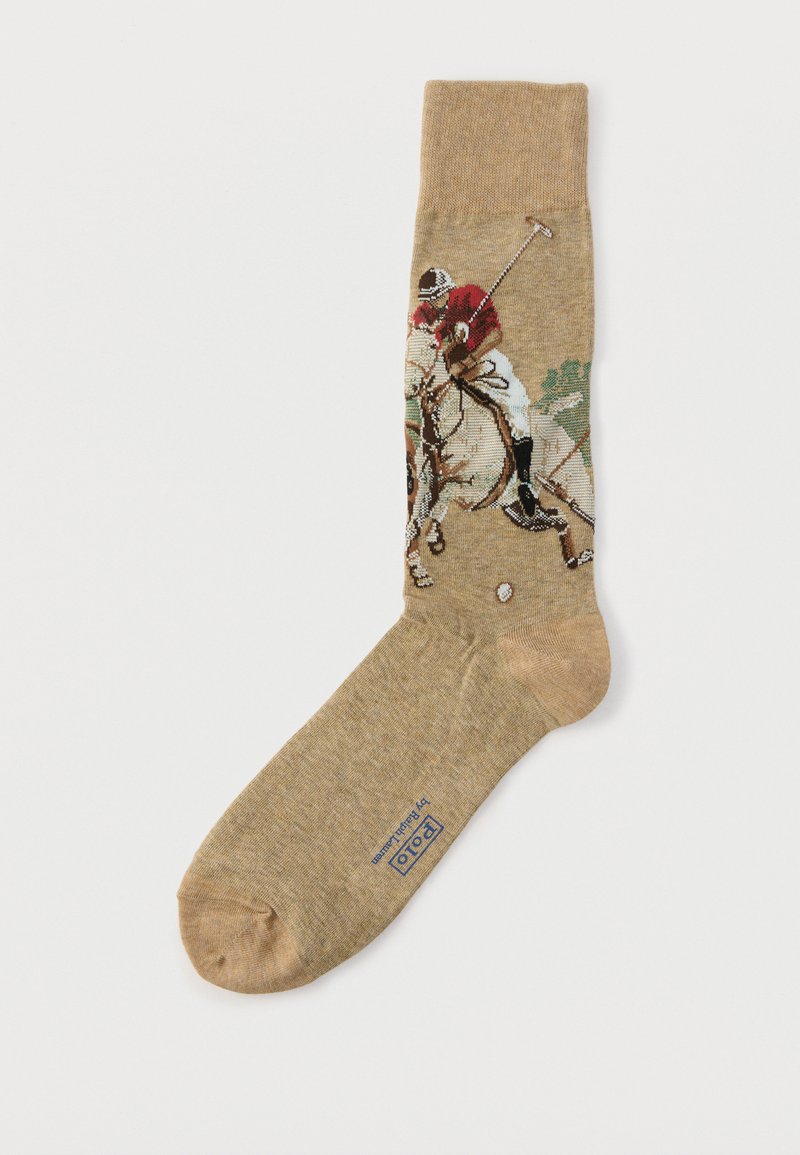 Ανοιχτό καφέ κάλτσα με έναν παίκτη πόλο με κόκκινο πουκάμισο που ιππεύει ένα άσπρο άλογο, κουνώντας μια ράβδο προς μια μπάλα.