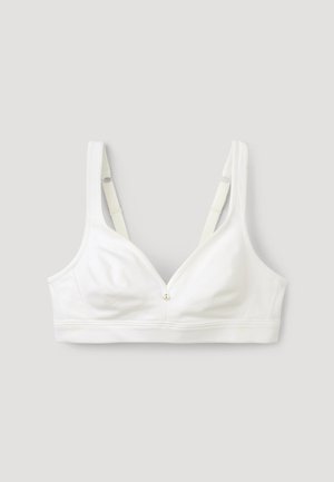 Witte soft-cup bh met brede banden, met een V-hals ontwerp en een klein gouden embleem in het midden. Gladde textuur en elastische band.