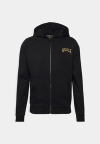 Sudadera con cremallera negra hecha de tela suave, con un bolsillo canguro y un logo dorado bordado en el lado izquierdo del pecho.