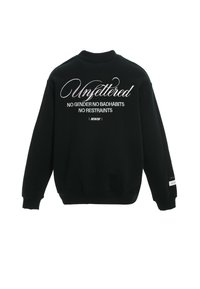 Sudadera negra con cuello alto, mangas largas y texto blanco en la espalda: "Sin restricciones Sin género Sin malos hábitos Sin limitaciones."