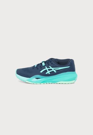 Chaussure de sport bleu marine et turquoise avec lacets et semelle rembourrée, vue de côté sur un fond clair uni.