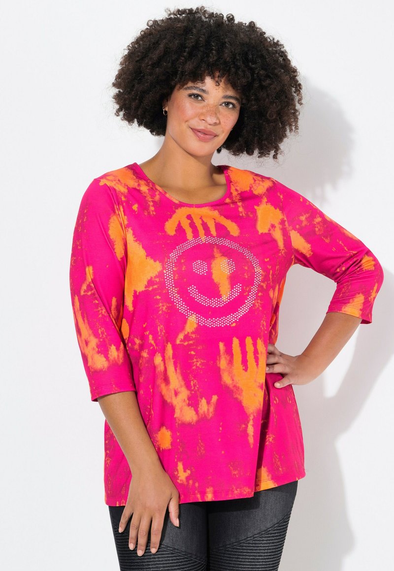 Rosa und orangefarbener Batikshirt mit Dreiviertelärmeln, das ein Strass-Smiley-Gesicht-Design auf der Vorderseite hat. Weicher, lässiger Stoff.