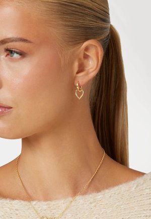 Gouden oorbellen met hartvormige accenten; voorzien van een gedraaid ontwerp en ingelegde details voor extra textuur en glans.