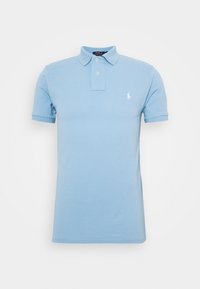 Ljusblå kortärmad pikétröja med krage, två knappar och en liten vit broderad logotyp på vänster bröst.