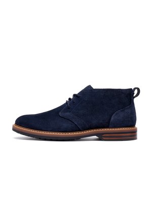 Navy blue suede leather ankle boot with brown stitched sole, lace-up front, and black rubber tread heel.