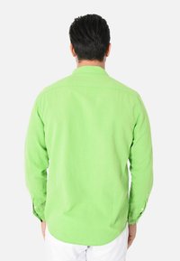 Camicia verde a maniche lunghe realizzata in tessuto leggero, con colletto a punta, polsini regolabili e orlo curvo.