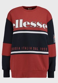 Czerwony i granatowy sweter z okrągłym dekoltem z dużym białym logo "ellesse", poziomymi paskami i haftowanymi detalami. Wykonany z miękkiej tkaniny.